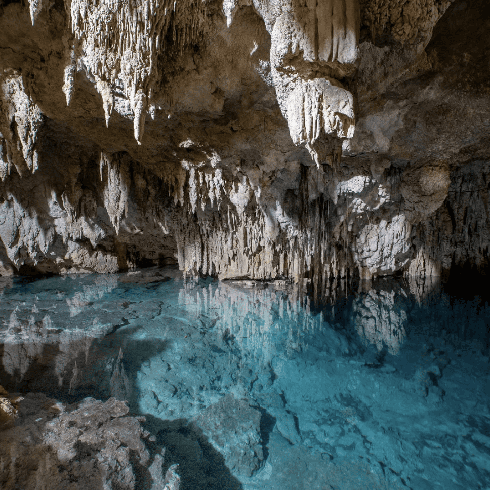 Underground cenote with stalactites and turquoise water